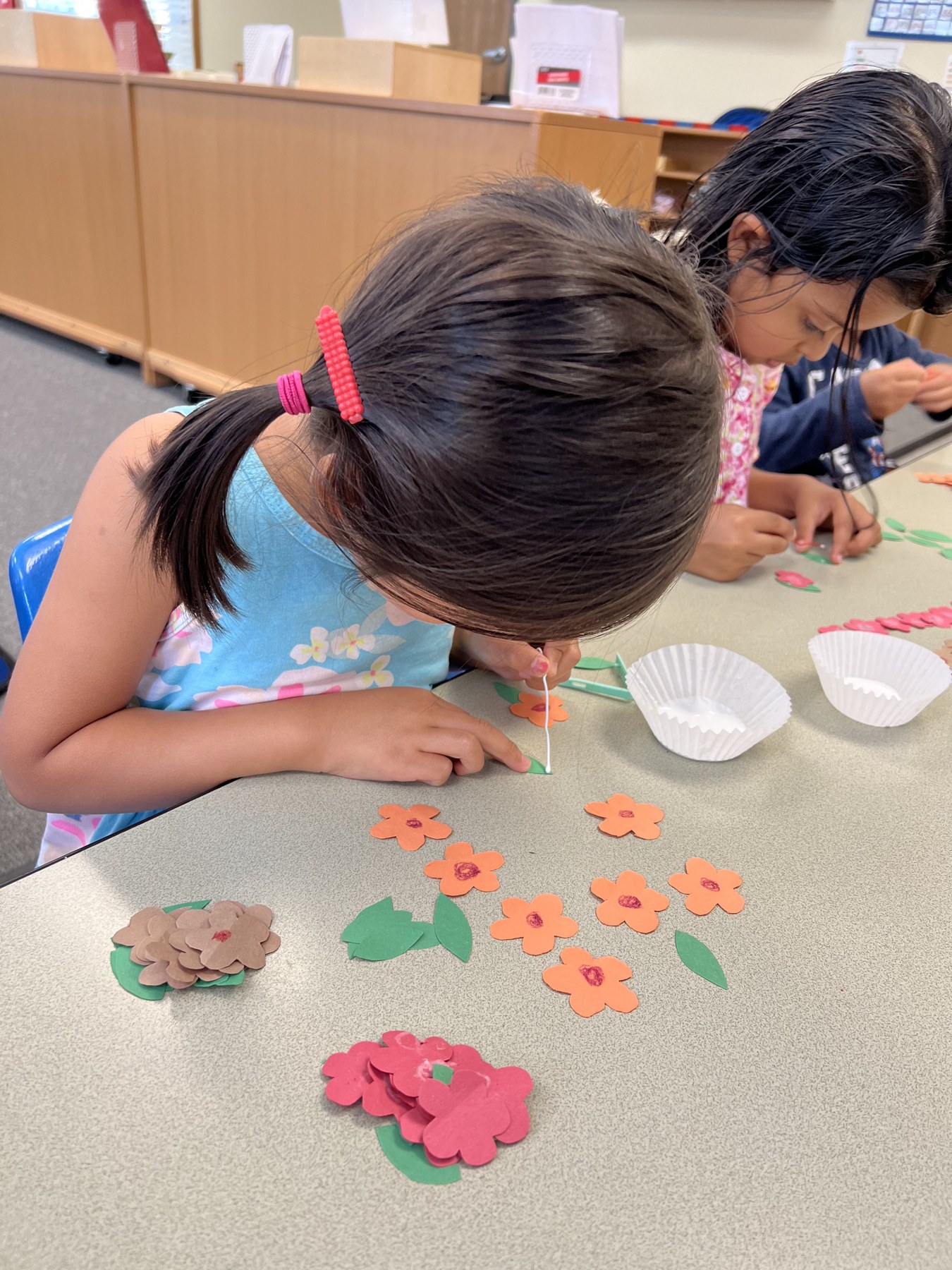 A child arranging paper flowers during an art project