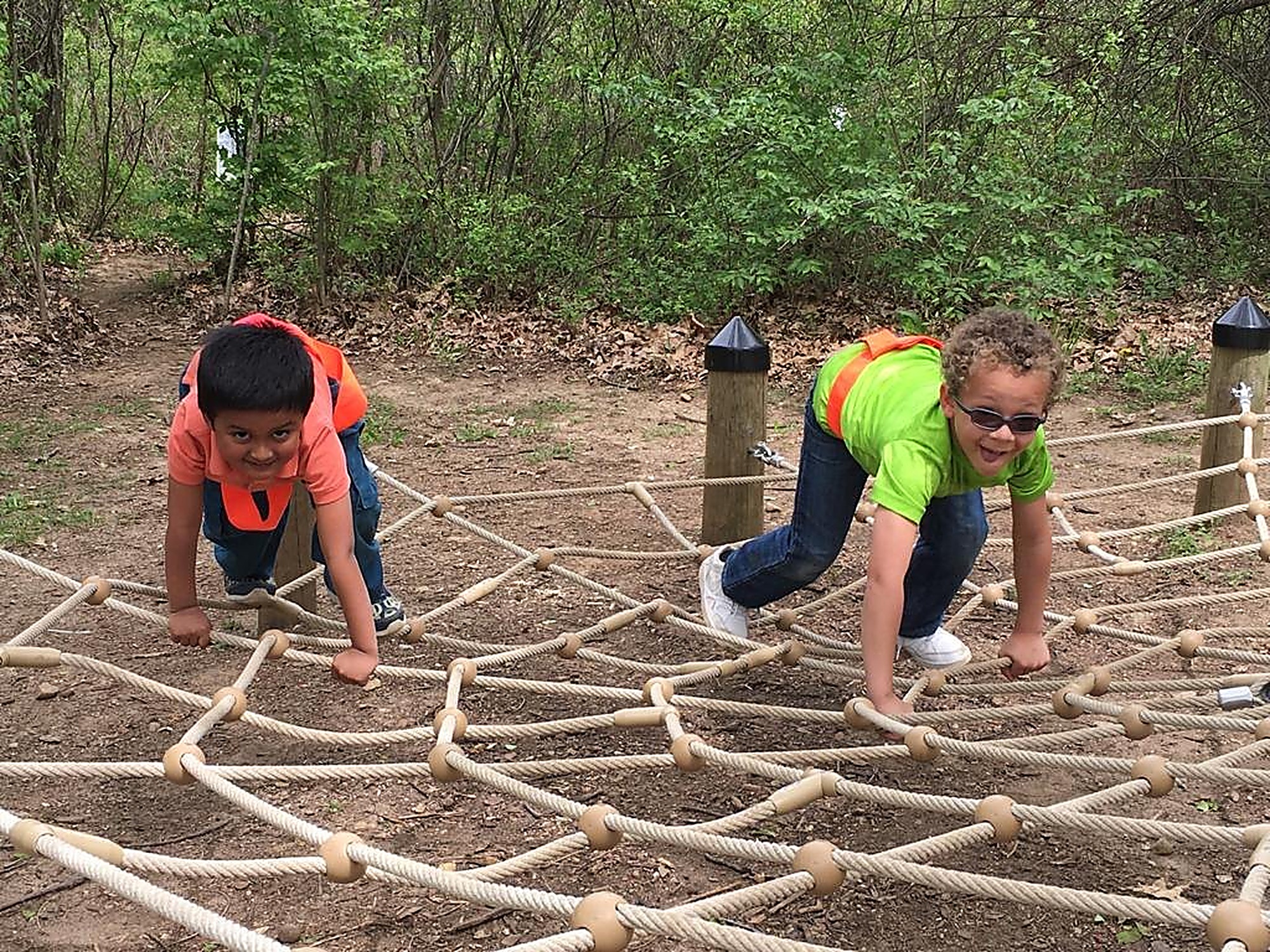 A child navigating a rope course during a summer adventure day