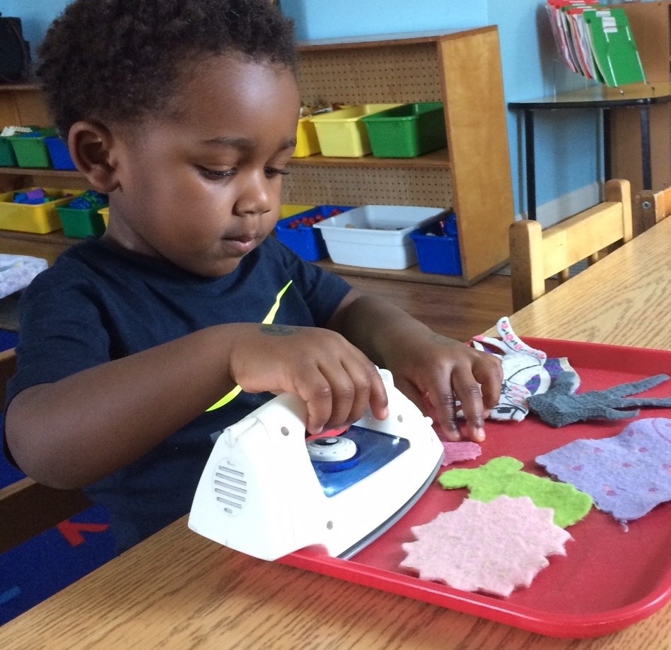 A child ironing at a Practical Life work station
