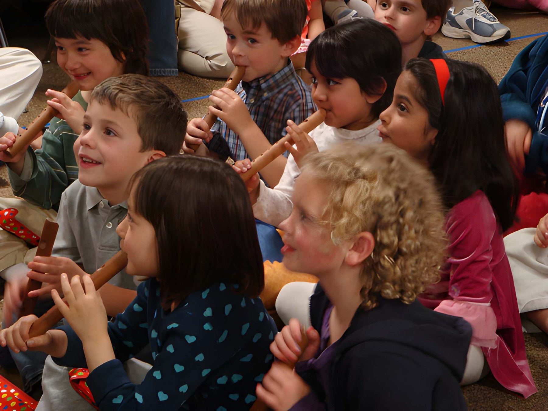 Children playing recorders together during a music lesson