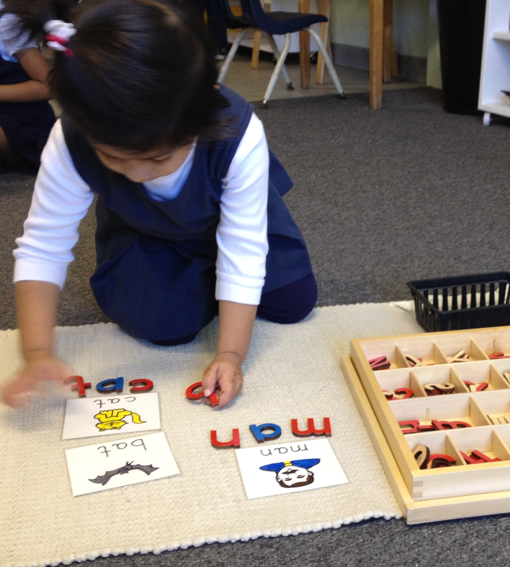 A child matching Montessori language picture cards
