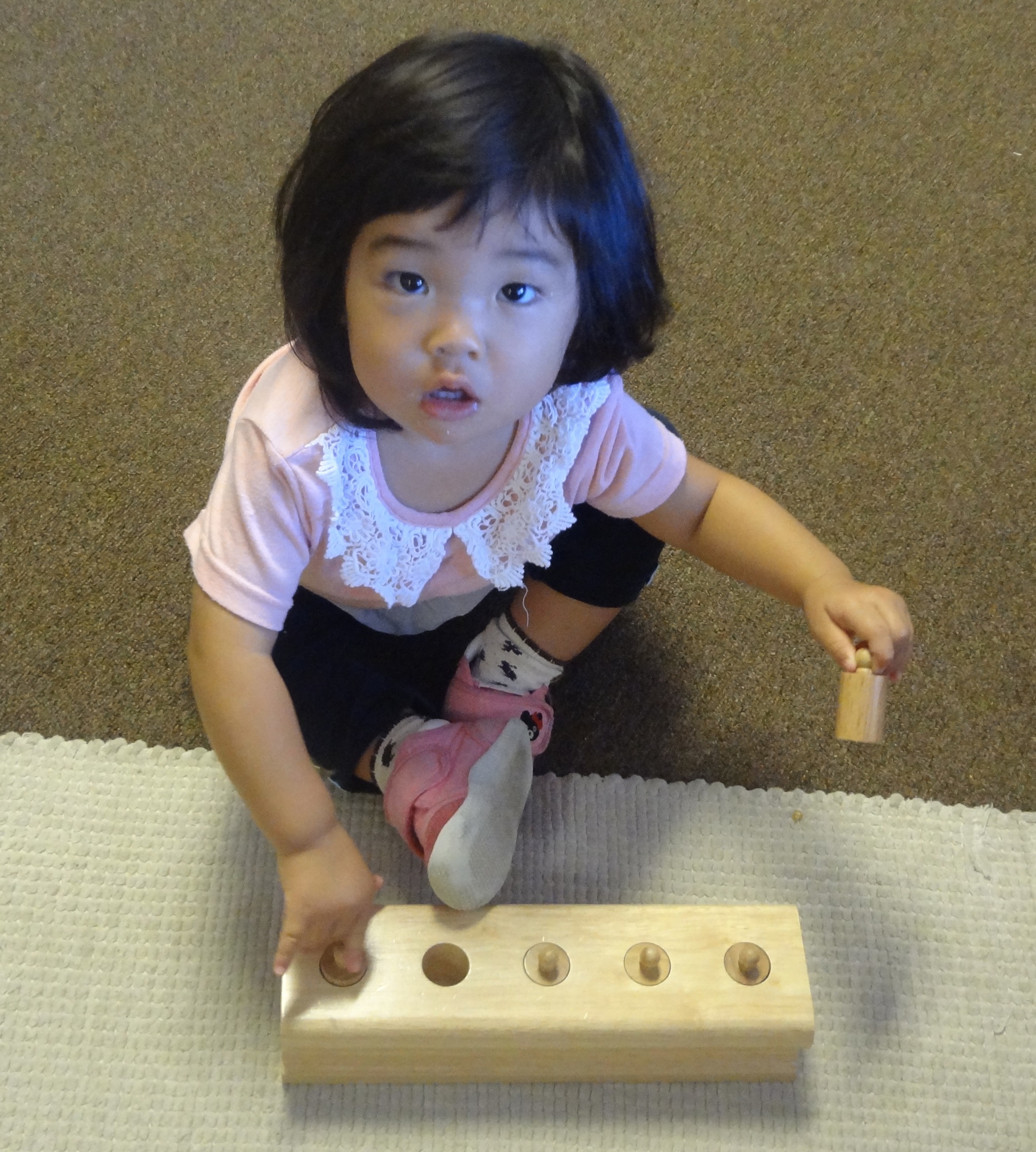 A child working with the Montessori cylinder blocks